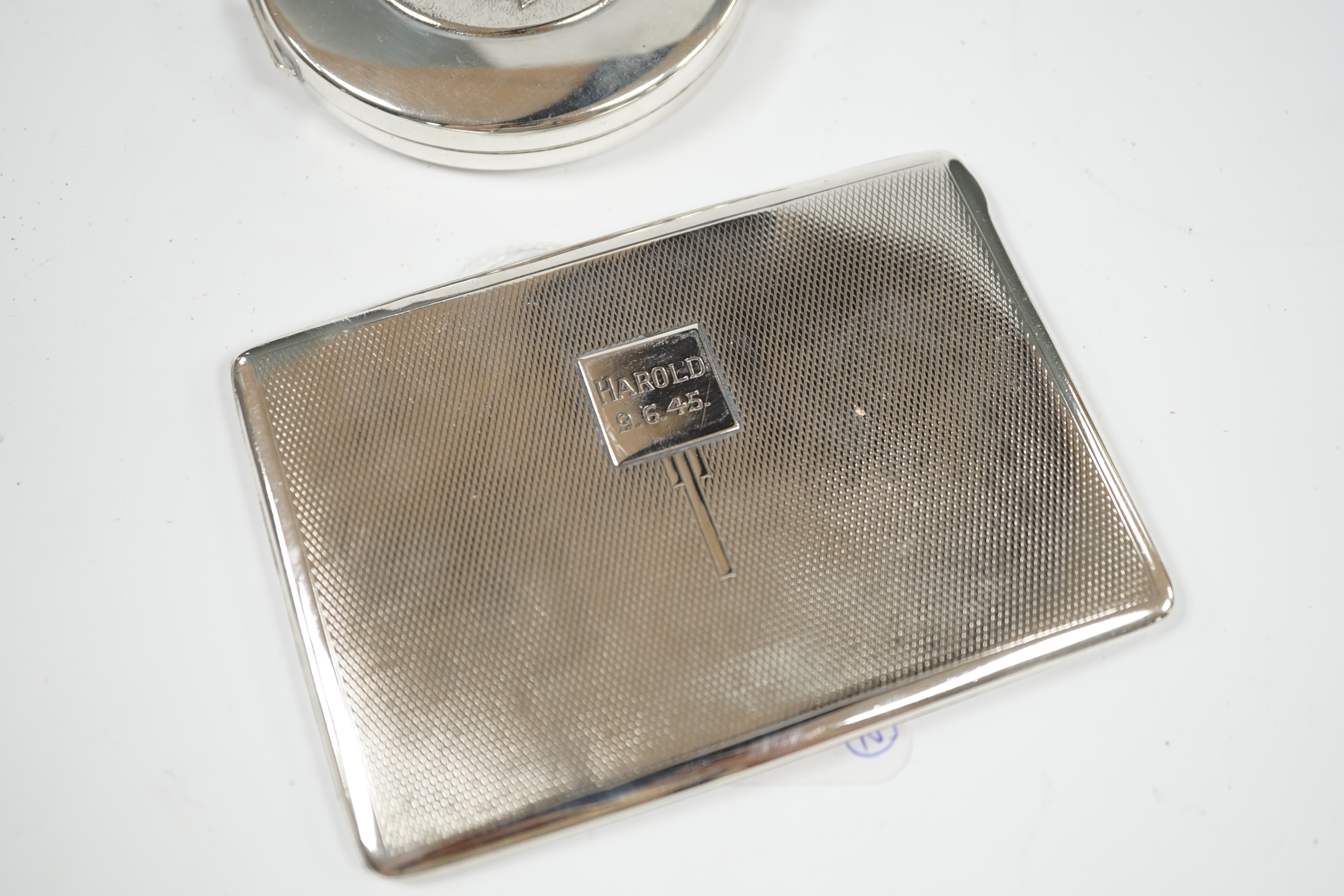 A George VI engine turned silver cigarette case, 11.5cm, together with a Spanish white metal compact. Condition - poor to fair